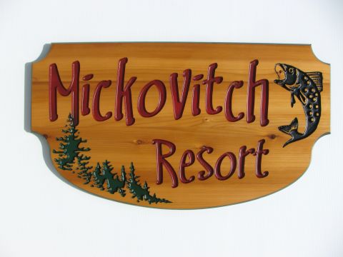 Engraved wooden sign with trees and fish